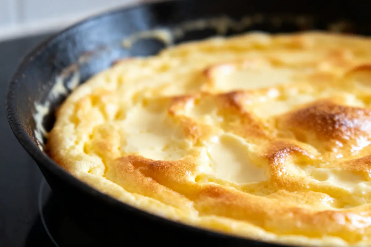 Omelette dorée cuite au four dans une poêle en fonte noire.