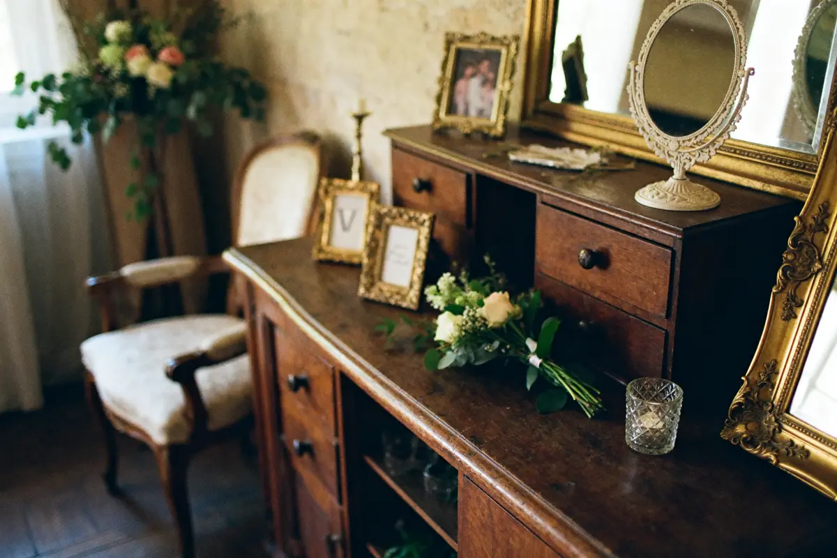 Commode vintage avec cadres dorés et bouquet pour location de décoration pour un mariage