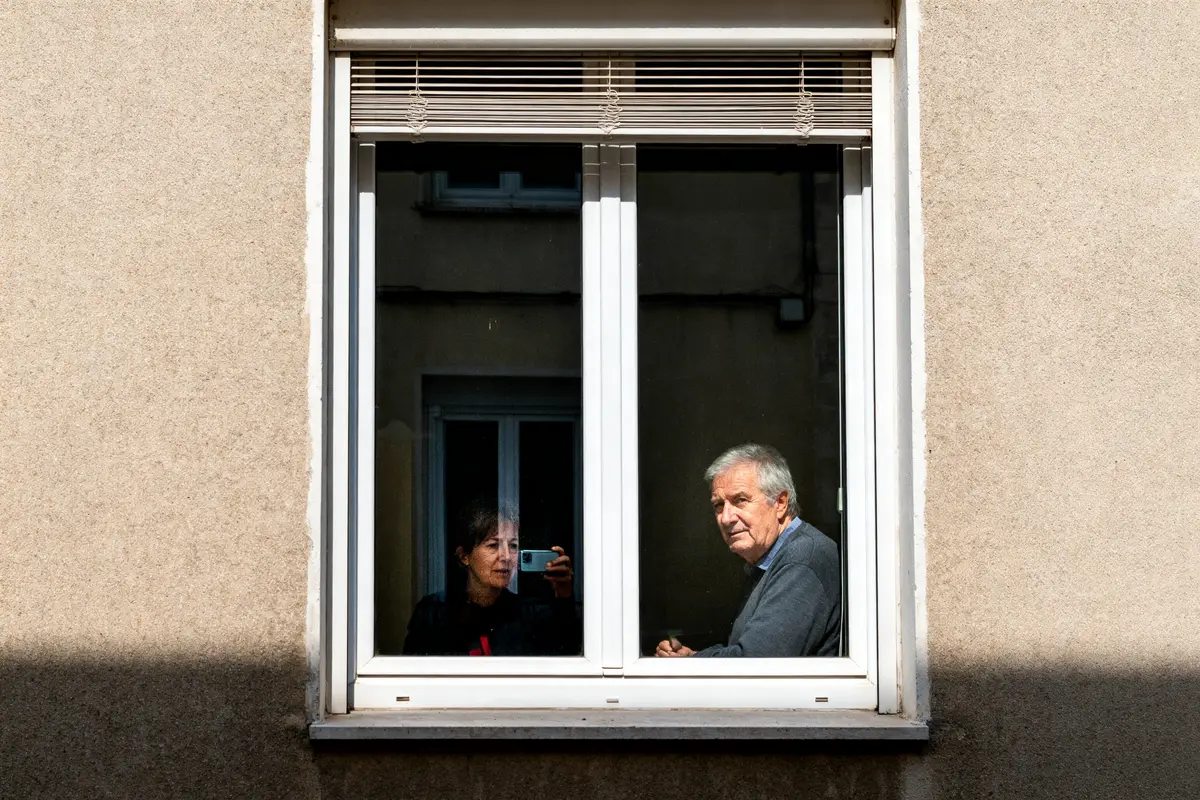 Deux personnes assises derrière une fenêtre PVC avec système d'aération intégré