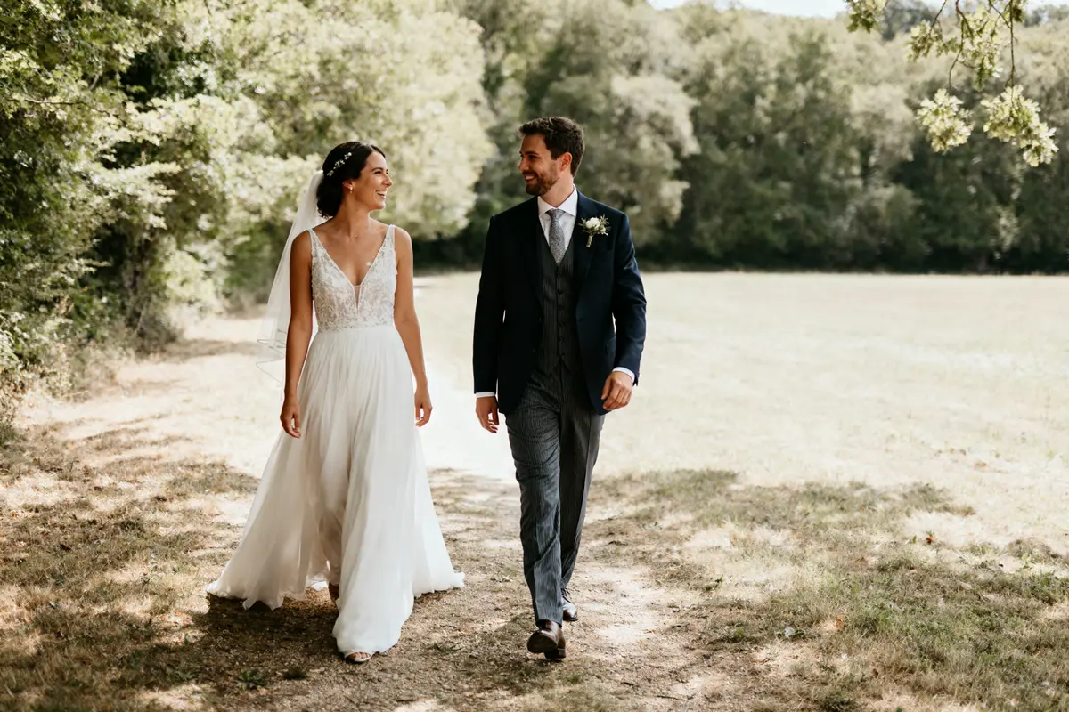 Couple marchant dans un parc avec une élégante tenue pour un mariage élégant et champêtre