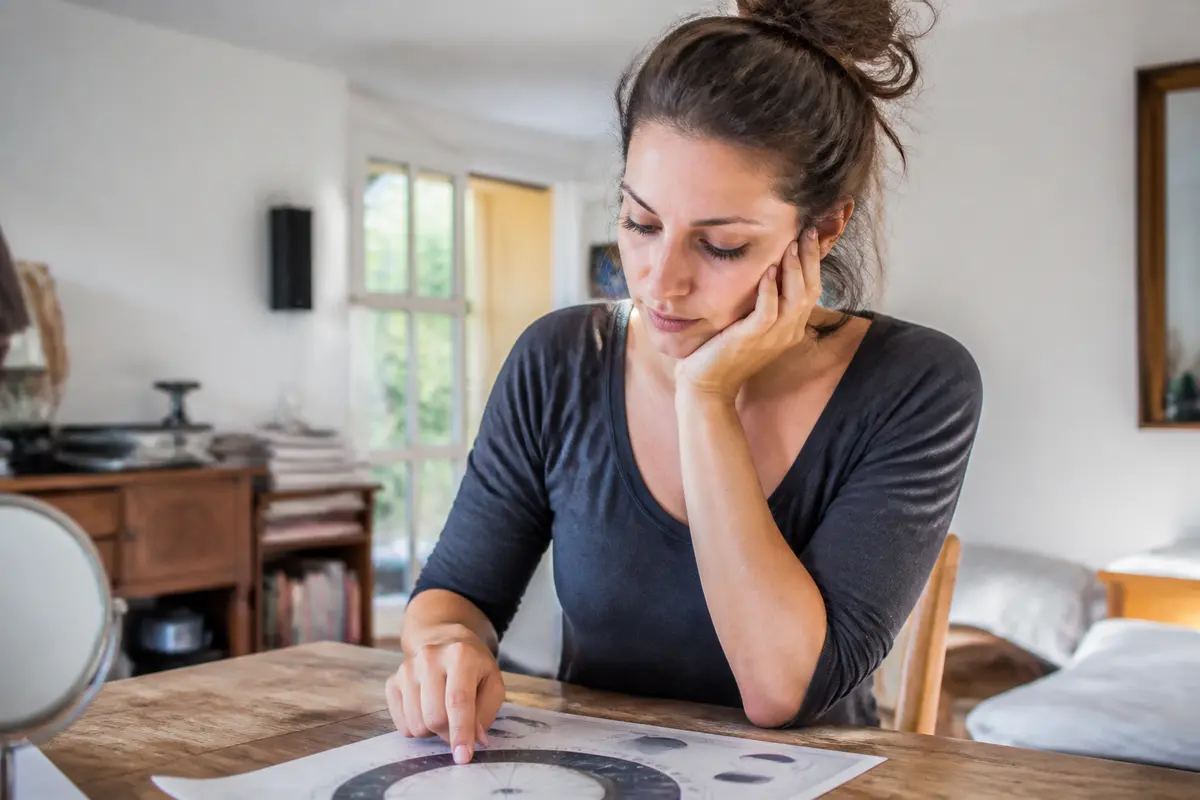 Femme concentrée sur un graphique pour le calcul du signe lunaire astrologique